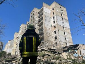 Рятувальник ДСНС біля пошкодженого будинку